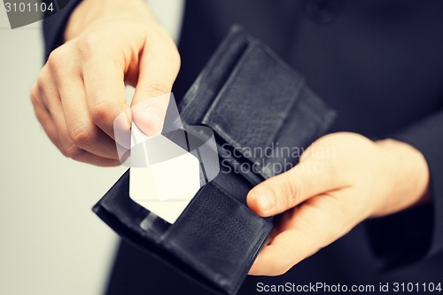 Image of man in suit holding credit card