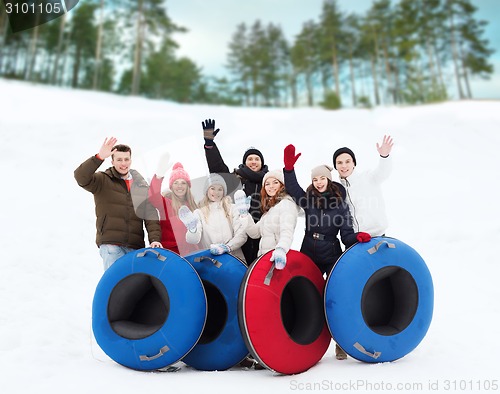 Image of group of smiling friends with snow tubes