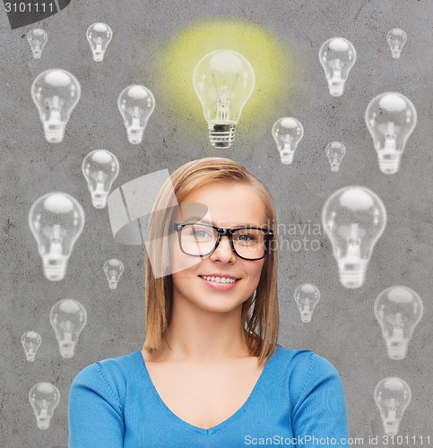 Image of smiling young woman in eyeglasses having idea