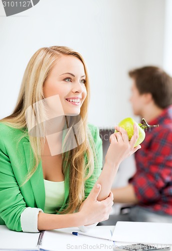 Image of student girl with green apple in college