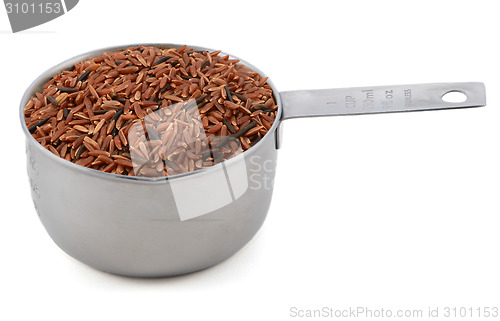 Image of Camargue red rice grains in a cup measure