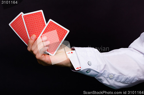 Image of man's hand holding three cards and the ace in the hole