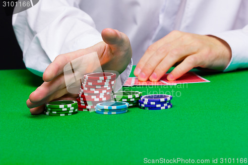 Image of Man puts in the casino. Hand with chips