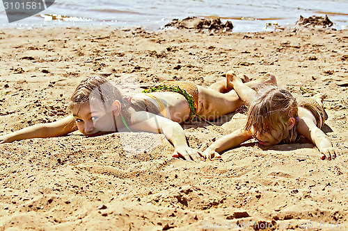 Image of Two girls on sand by the river