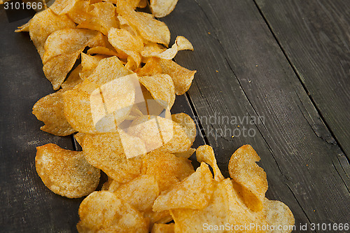 Image of potato chips on a wooden background