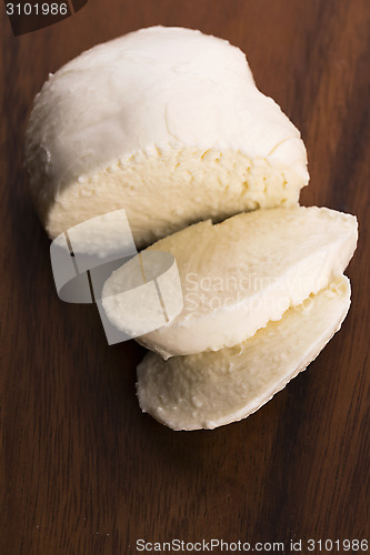 Image of Sliced mozzarella on wooden board 