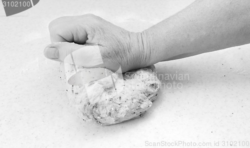 Image of Woman kneading bread dough by hand