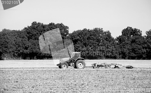 Image of Tractor and harrow cultivating the soil