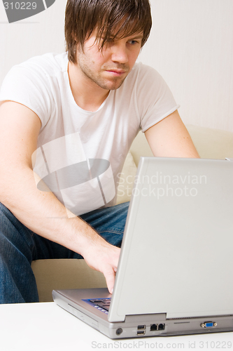 Image of young man home with laptop