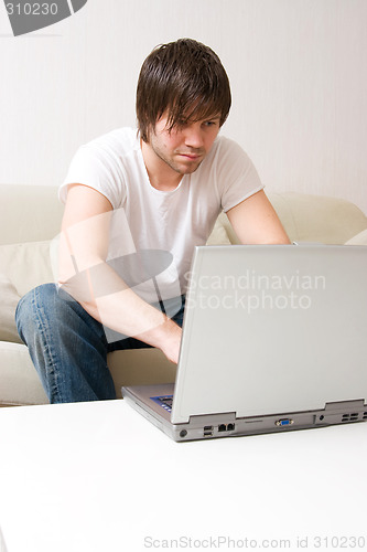Image of young man home with laptop