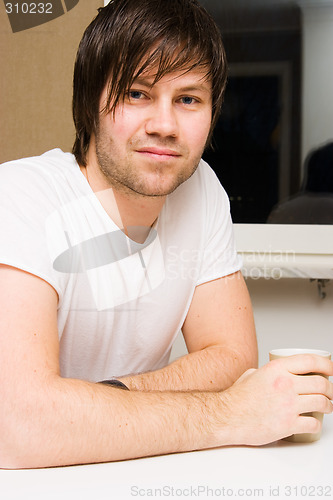 Image of young man with cup of tea or coffee