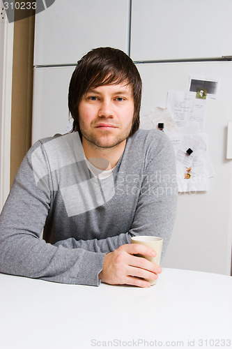 Image of young man with cup of tea or coffee