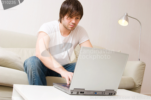 Image of young man home with laptop