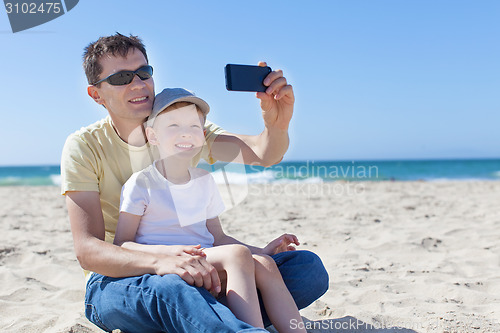 Image of family taking selfie at the beach