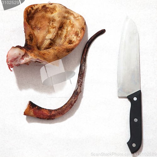 Image of pork ears with knife and blood white background.