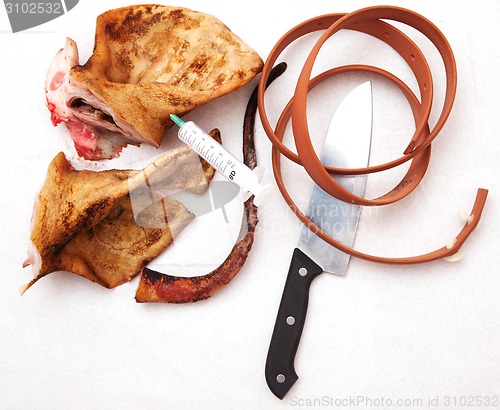 Image of pork ears with knife and blood white background.
