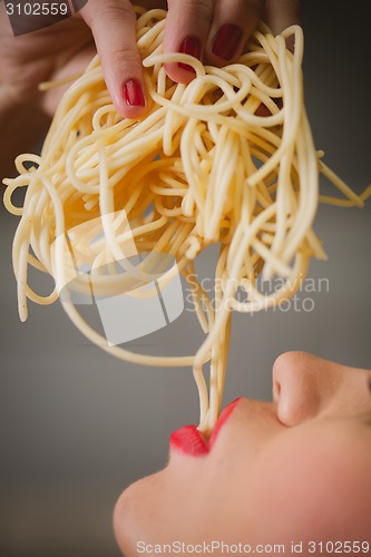 Image of attractive woman with eating spaghetti.