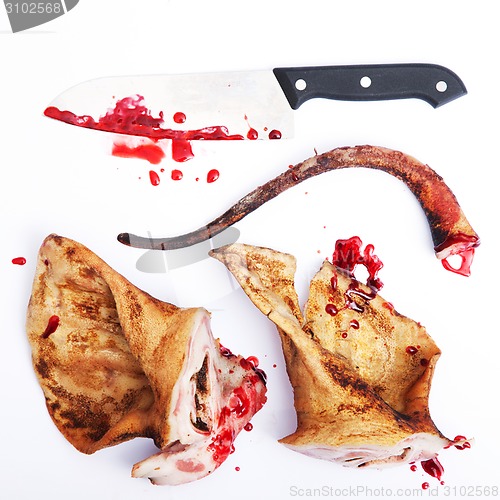 Image of pork ears with knife and blood white background.