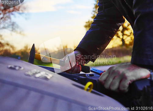 Image of Hooligan breaking into car