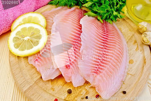 Image of Tilapia with parsley and lemon on board