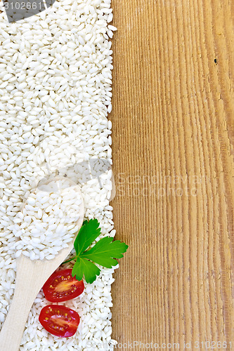 Image of Rice white with spoon and tomatoes on board