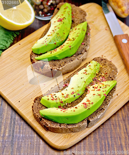 Image of Sandwich with avocado and lemon on board