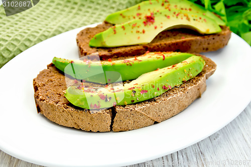 Image of Sandwich with avocado and pepper on light board