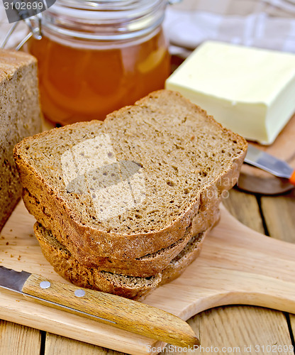 Image of Rye homemade bread with honey and butter on board