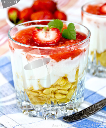 Image of Dessert milk with strawberry and flakes in glass on napkin