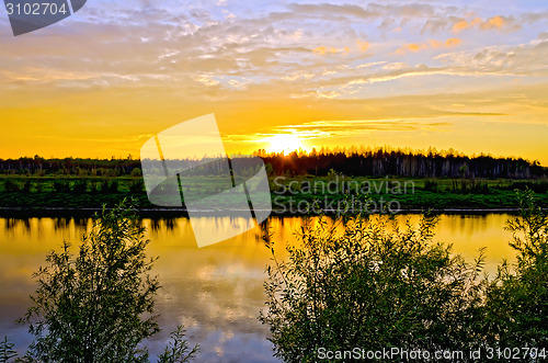 Image of Sunset on river with trees and bushes