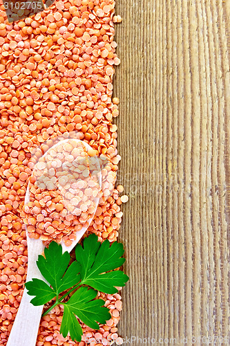 Image of Lentils red with spoon and parsley on board