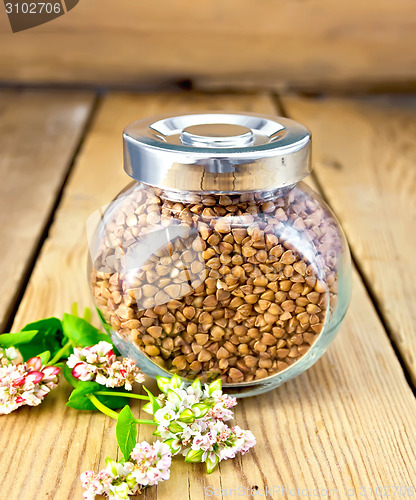 Image of Buckwheat in glass jar and flower on board