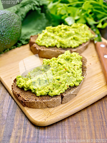 Image of Sandwich with guacamole on dark board