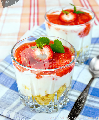 Image of Dessert milk with strawberry and flakes in glass on blue napkin