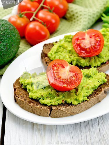 Image of Sandwich with guacamole and tomato on light board