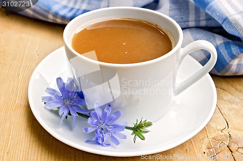 Image of Chicory drink in white cup with flower on board