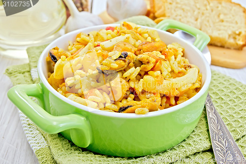 Image of Pilaf with seafood in green pot on board