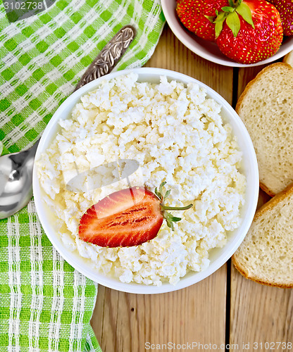 Image of Curd with strawberries in bowl on wooden board