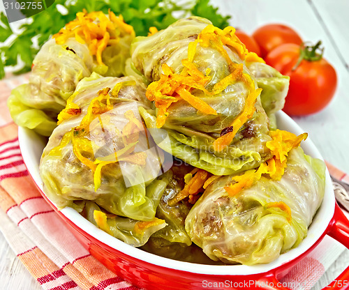 Image of Cabbage stuffed and carrots in brazier on red napkin