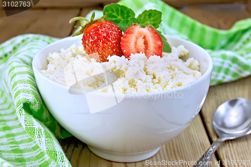 Image of Curd with strawberries in white bowl on board