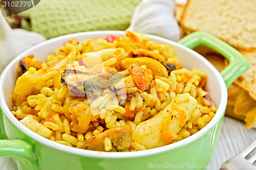 Image of Pilaf with seafood and bread on board