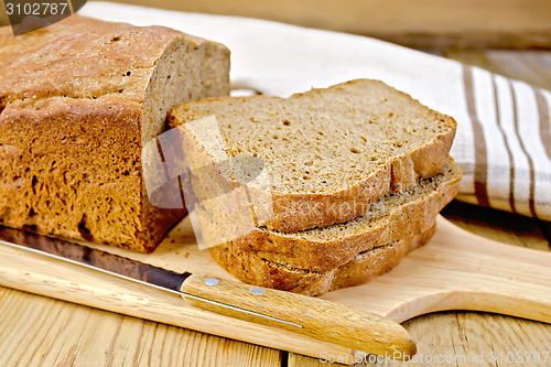 Image of Rye homemade bread stacked on board with napkin