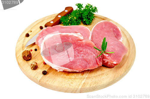 Image of Meat pork slices with spices on round board