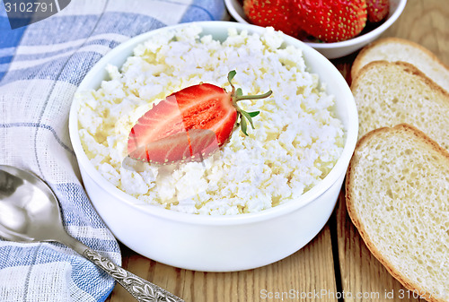 Image of Curd with strawberries in bowl and bread on board