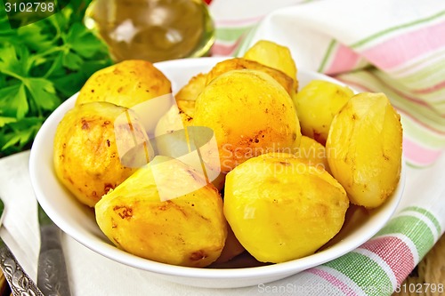 Image of Potatoes fried in plate with oil on light board