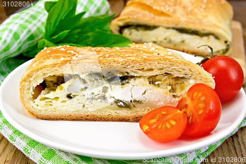 Image of Roll filled with spinach and cheese on wooden board