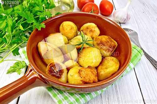 Image of Potatoes fried in ceramic pan on light board