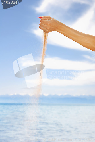 Image of Woman hand playing with sand