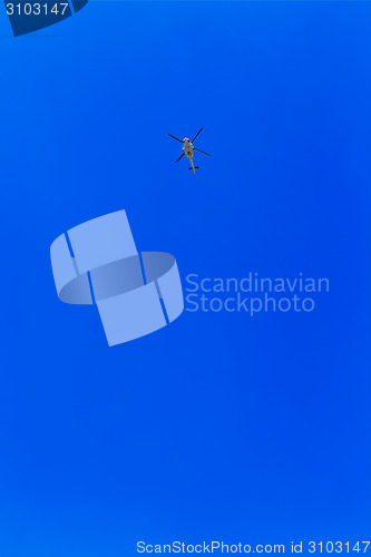 Image of helicopter flying against a blue sky