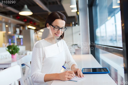 Image of smiling woman with tablet pc at cafe